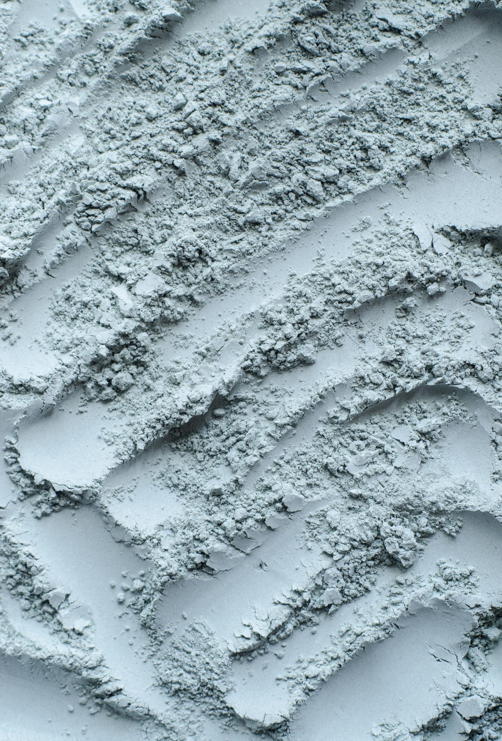 Gray, blue bentonite clay powder (alginate, facial mask, eye shadow, body wrap) texture close up, selective focus. Abstract background.